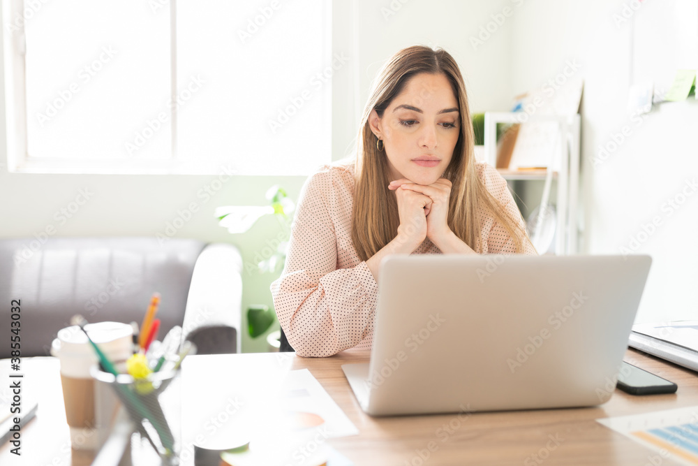 Poster Serious woman looking at a computer