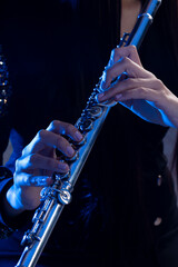 Close up of a silver flute played by a young girl