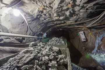 Wagons minecarts with gol ore in underground mine tunnel © Mishainik