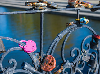 locks in the shape of a heart on a bridge.