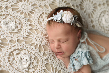 Beautiful sleeping Newborn gilr lies on the blue mint clothes color 