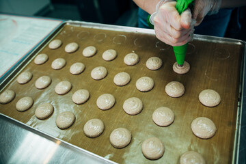 onfectioner making macaroons in pastry shop