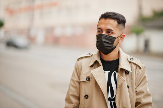 Stylish kuwaiti man at trench coat wear black face mask during covid pandemia.