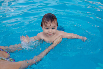 Fototapeta na wymiar Bebe en la piscina con la madre. 