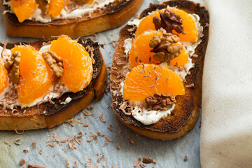 Delicious toast with sweet tangerine on black wood background