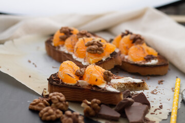 Delicious toast with sweet tangerine on black wood background