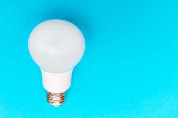 LED lamp flat lay on blue background. LED bulb. White energy-saving light bulb.Copy space