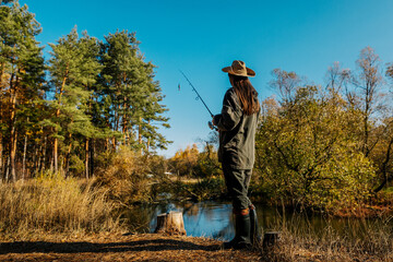Woman fishing on the river. Fishing on a spinning rod