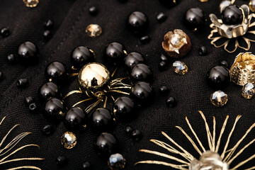 Embroidery of black and golden flower on fabric