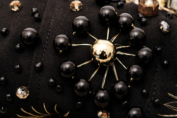Embroidery of flower with large black beads on fabric