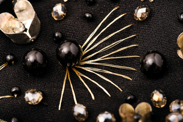 Flower of golden thread with black bead in the center