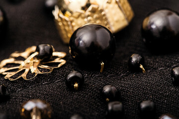 Macro large black bead with golden details on black fabric