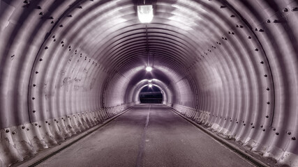 Large industrial stile illuminated tunnel with shadows on the walls