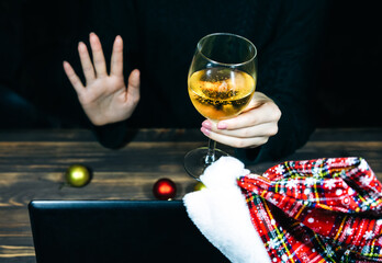 Christmas presents giving. Woman with champagne in glass speaking through video calls. Holidays in isolation. New decorations and lights. Family and friends celebrating online. Cozy atmosphere.