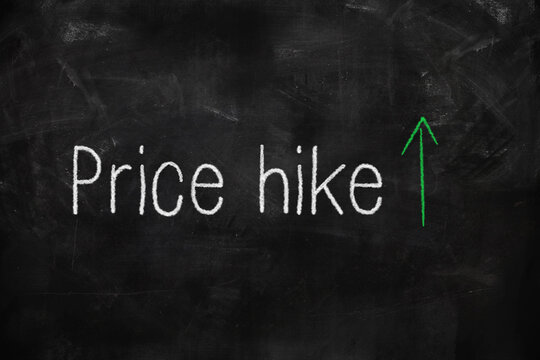 Price hike written with white and green chalk on blackboard in classroom