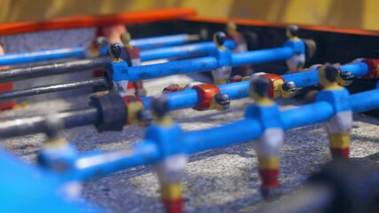 Young kids playing on old soccer football table rolling with the football players placing the ball in the game in local village in Ghana close up 50 fps