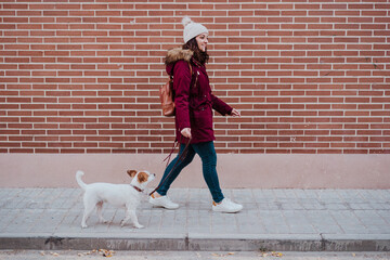 woman at the city walking with her adorable jack russell dog. Lifestyle outdoors