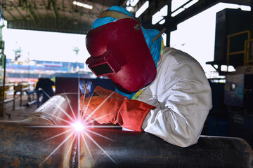 Welder is Welding process metal steel pipe, Industry Welder in factory protective equipment welding...