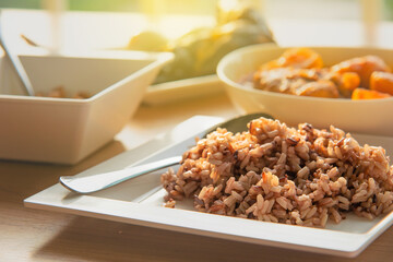 closeup of steamed brown rice with several side dish