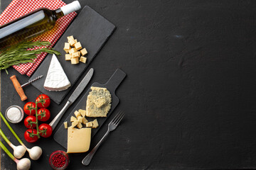 Composition with wine bottle and cheese assortment on grey background