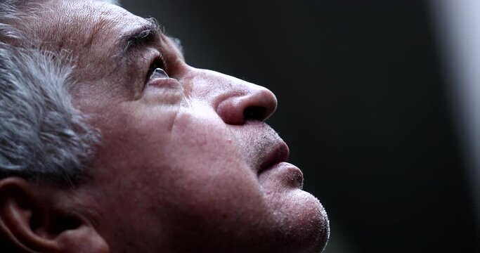 Older man in crisis looking at sky with hope and faith