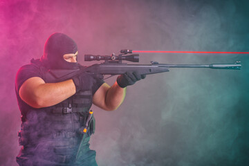 Soldier comes out of the smoke on the battlefield. The concept of military special operations. Aim...