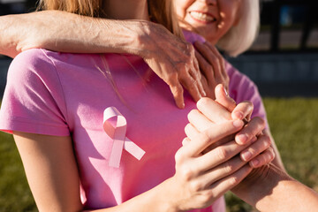 Fototapeta premium Selective focus of women embracing and holding hand outdoors