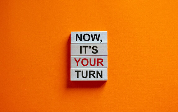 Wooden blocks form the words 'now, its your turn' on beautiful orange background. Business concept. Copy space.