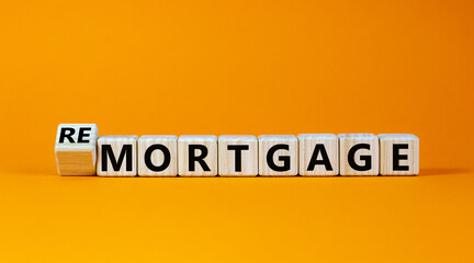 Turned a cube and changed the word 'remortgage' to 'mortgage' or vice versa. Beautiful orange background, copy space. Business concept.