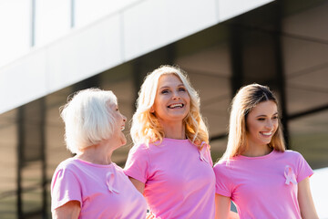 Selective focus of women with signs of breast cancer awareness laughing outdoors