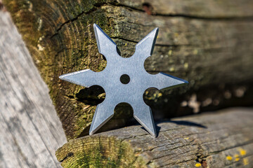 Shuriken (throwing star), traditional japanese ninja cold weapon stuck in wooden background