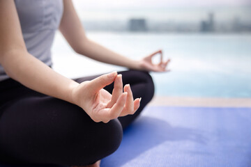 Woman Practicing Yoga with Sukhasna Pose Near the Pool