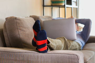 Young millennial businessman, freelancer working from home on the couch