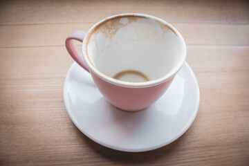 Empty cup of cappuccino, top view. Pink cup of coffee on wooden table. Empty coffee mug on white plate. Breakfast concept. Finish of dinner. Coffee cup isolated.