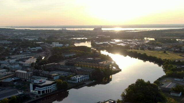 Aerial of Christina River draining into Delaware River in Wilmington, DE, USA. Beautiful morning sunrise reflection on water.