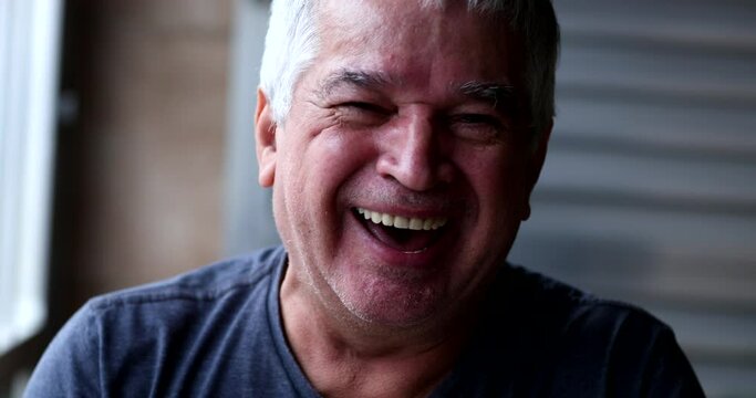 Older man laughing uncontrollably, happy person in 60s laugh out loud