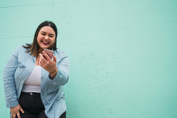 Young plus size woman using her mobile phone.