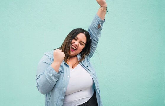 Young plus size woman celebrating victory.