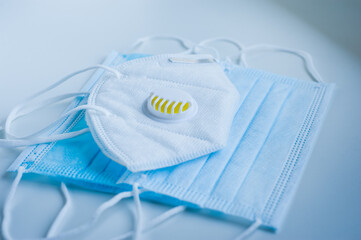 Respirator with exhalation valve and medical protective masks on a blue background