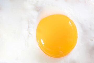 Fried egg yolk close-up, macro photography. Breakfast concept, natural protein food.