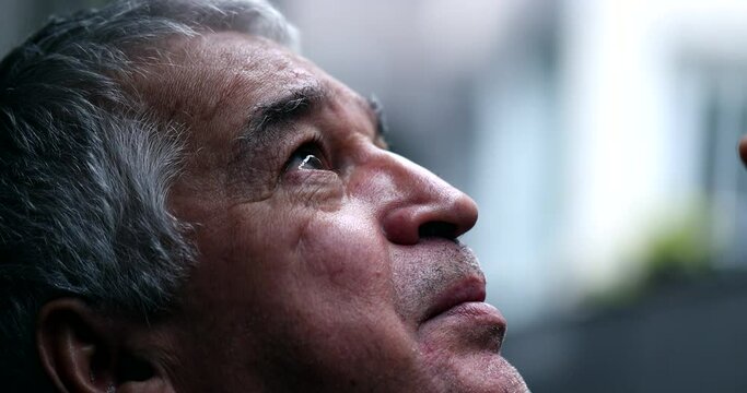 Older man in crisis looking at sky with hope and faith