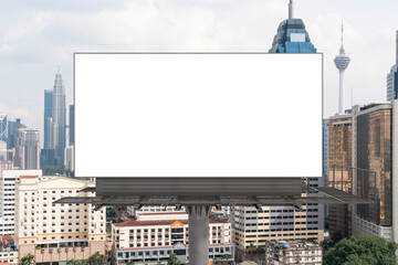Obraz premium Blank white road billboard with KL cityscape background at day time. Street advertising poster, mock up, 3D rendering. Front view. The concept of marketing communication to promote or sell idea.