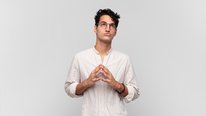 young handsome man scheming and conspiring, thinking devious tricks and cheats, cunning and...