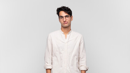 young handsome man feeling confused and doubtful, wondering or trying to choose or make a decision