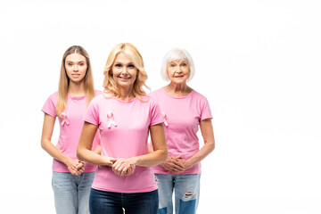 Obraz premium Concept of breast cancer awareness with women in pink t-shirts with ribbons isolated on white