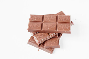 Milk chocolate pieces isolated on white background from top view, close up a chocolate bar isolated on white background