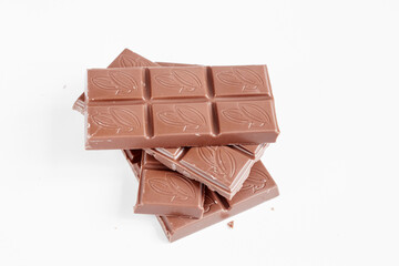 Milk chocolate pieces isolated on white background from top view, close up a chocolate bar isolated on white background