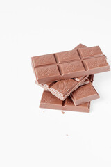 Milk chocolate pieces isolated on white background from top view, close up a chocolate bar isolated on white background