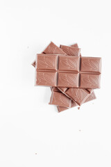 Milk chocolate pieces isolated on white background from top view, close up a chocolate bar isolated on white background