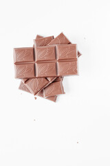 Milk chocolate pieces isolated on white background from top view, close up a chocolate bar isolated on white background
